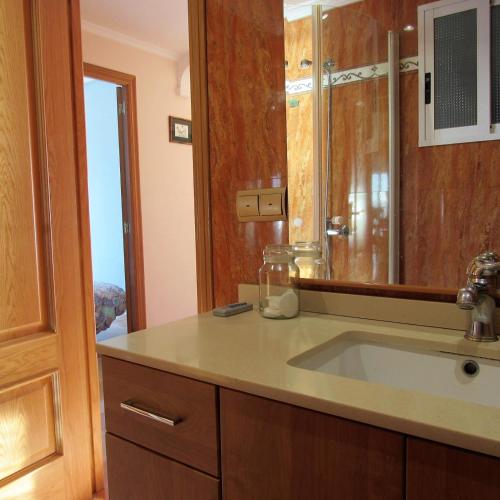 a bathroom with a sink and a mirror and a window at Edificio Montecarlo Playa San Juan in El Campello