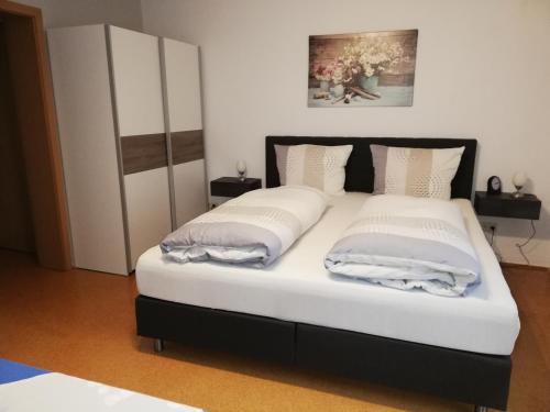 a bed with two pillows on it in a room at Ferienhaus Brütting in Pottenstein