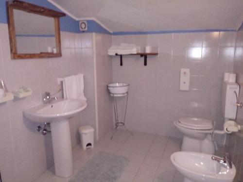 een witte badkamer met een wastafel en een toilet bij Il rifugio nel parco in Villetta Barrea