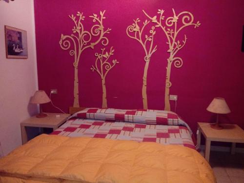 a bedroom with a purple wall with trees painted on it at Il rifugio nel parco in Villetta Barrea