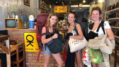 three girls are posing for a picture in a store at OK CHIC PHUKET HOSTEL in Phuket Town