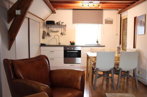 ein Wohnzimmer mit einem Tisch und Stühlen sowie eine Küche in der Unterkunft het Bakkershuisje in Colijnsplaat