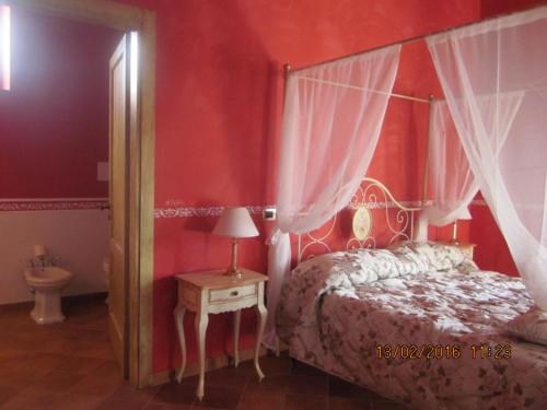 1 dormitorio con cama con dosel y mesa con lámpara en B&B Il Casone di Drusa, en San Marco dei Cavoti