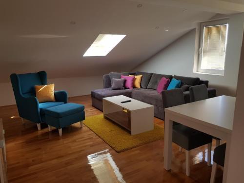 a living room with a couch and two chairs at Family Apartments in Zaječar