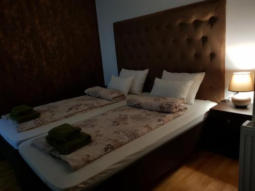 a bedroom with a bed with two pillows on it at Family Apartments in Zaječar