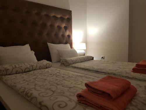 two beds in a hotel room with towels on them at Family Apartments in Zaječar