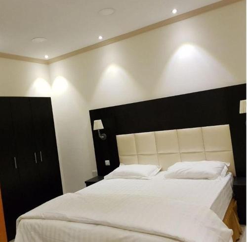 سرير أو أسرّة في غرفة في روح الأصيلة للشقق المخدومة Roh Alaseilah Serviced Apartments