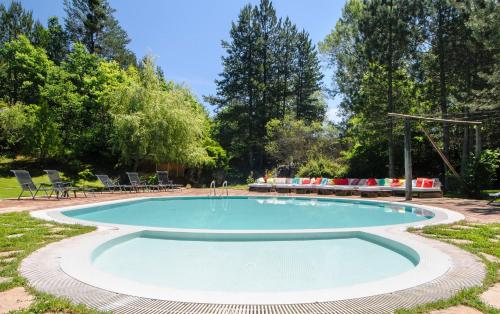 a swimming pool in a park with chairs and trees at Omaya Eco Village in Gaytaninovo