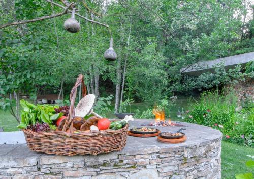 a basket of vegetables sitting on a stone table at Omaya Eco Village in Gaytaninovo