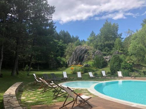 a pool with chaise lounge chairs and a group at Omaya Eco Village in Gaytaninovo