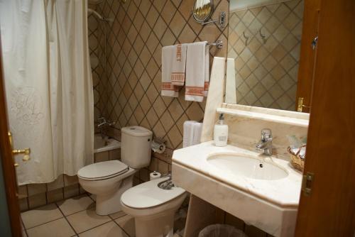 a bathroom with a toilet and a sink at Hotel Rural Jaumet in Torá de Rulbregos