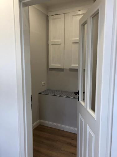 a room with a kitchen with white cabinets and a door at Gestorfer Kötnerhof Business und Landlust in Springe