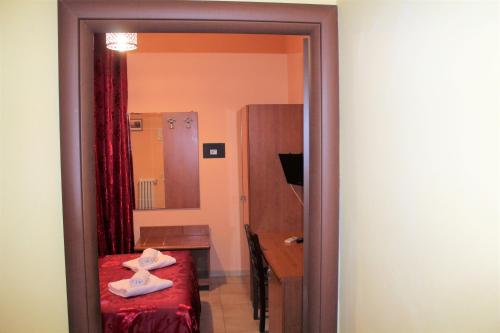 a room with a bed and a desk and a mirror at Hotel Eurorooms in Rome