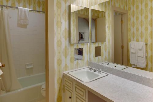y baño con lavabo, espejo y bañera. en Stony Court at Bryce Mountain by Capital Vacations, en Basye