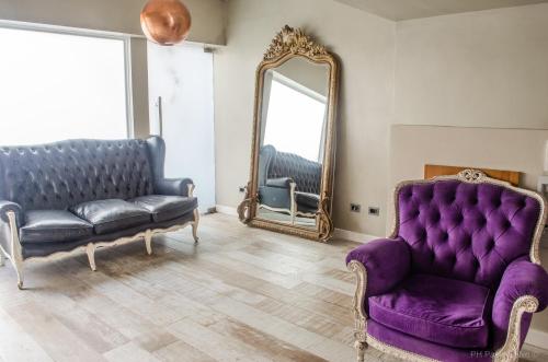 a living room with a purple couch and a mirror at Syrah Studios in Buenos Aires