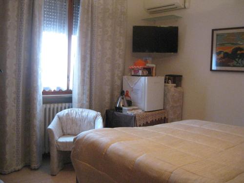 a bedroom with a bed and a chair and a window at Da Lorella in Gabicce Mare
