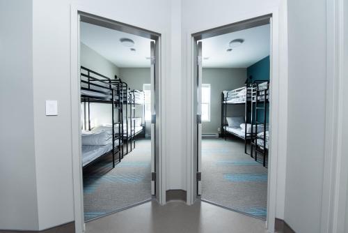 a hallway with two bunk beds and two mirrors at Nowhere Special Hostel in Rossland