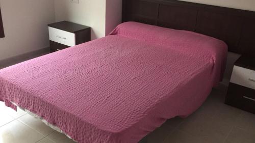 a bedroom with a pink bed with two night stands at Vistamar Galicia in Ribeira