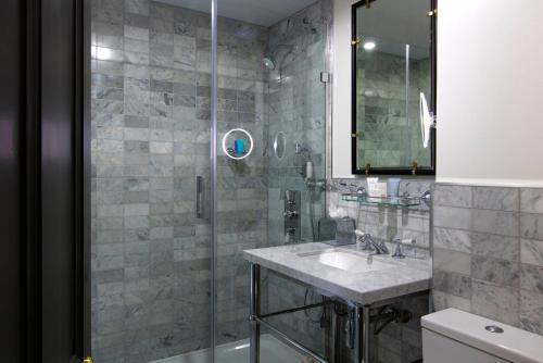 a bathroom with a shower, sink, and mirror at The Academy - Small Luxury Hotels of the World in London