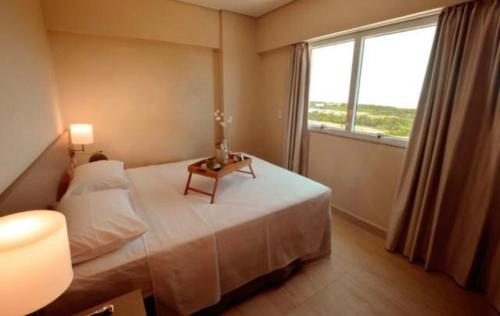 um quarto com uma cama com uma mesa e uma janela em Salinas Park Resort em Salinópolis