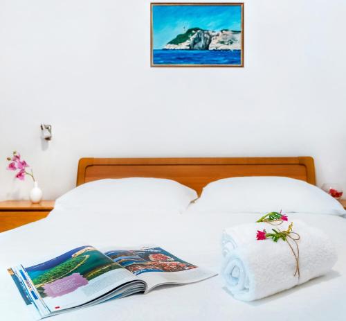een bed met een boek en een boek bij Apartments Velo Lago in Lastovo
