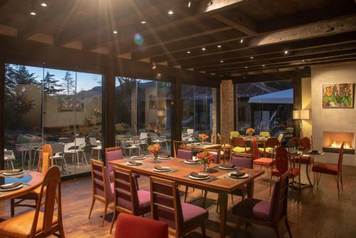 a dining room with tables and chairs and a fireplace at Uvence Arte + Hotel in San Cristóbal de Las Casas