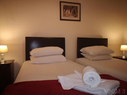 1 dormitorio con 2 camas y toallas. en Westgate Hotel, en Oxford