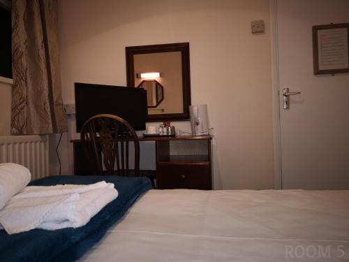 a bedroom with a bed and a desk with a mirror at Westgate Hotel in Oxford