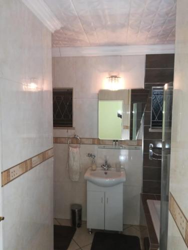 a bathroom with a sink and a mirror at Lalela House in Johannesburg