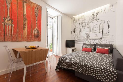 リスボンにあるChão do Loureiro Apartments Baixa-Castleのベッドとテーブルと机のある寝室