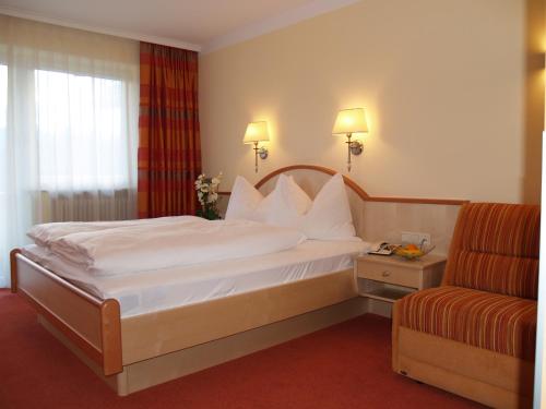 レルモースにあるTirolerhofのベッドと椅子付きのホテルルーム