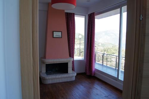 a living room with a fireplace and a balcony at Calypso Apartments in Vathi, Ithaka