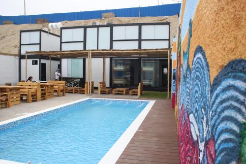 a wall with a mural next to a swimming pool at Surfari Punta Rocas in Punta Negra