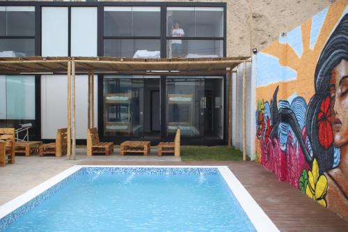 a mural on the side of a building with a swimming pool at Surfari Punta Rocas in Punta Negra