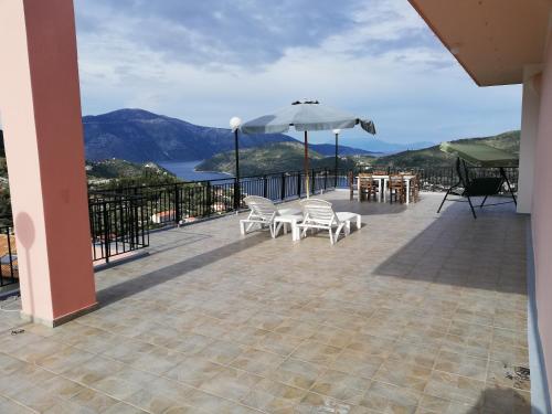 a patio with a table and chairs and an umbrella at Calypso Apartments in Vathi, Ithaka