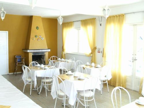 a dining room with white tables and white chairs at Hotel Alpinus in Joinville