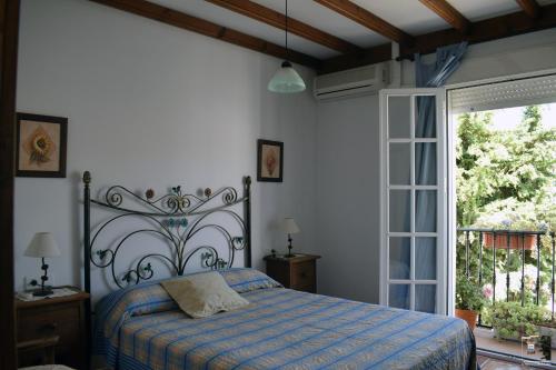 a bedroom with a bed and a large window at Casa Rural El Puente in Cuevas del Becerro