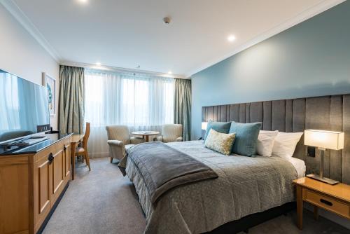 a hotel room with a bed and a television at Distinction Christchurch Hotel in Christchurch