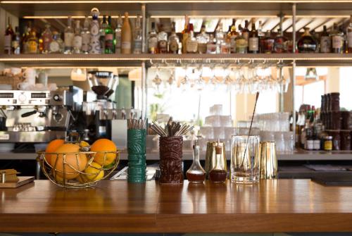 a bar with a bowl of oranges and glasses at Queen Kapiolani Hotel in Honolulu
