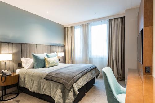 a hotel room with a bed and a television at Distinction Christchurch Hotel in Christchurch