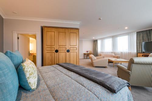 a bedroom with a large bed and a living room at Distinction Christchurch Hotel in Christchurch