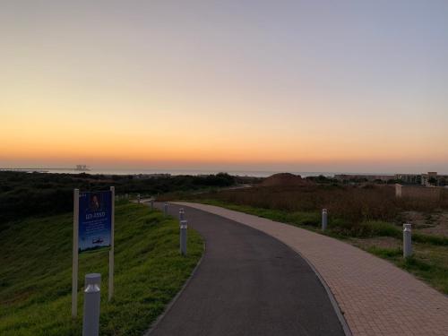 a winding road with the sunset in the background at Different Atmosphere Suite in Caesarea