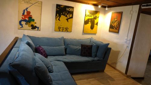 a blue couch in a living room with posters on the wall at The old olive mill house in Aegae