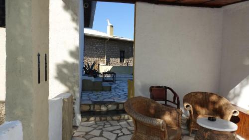 a patio with two chairs and a table on a porch at The old olive mill house in Aegae