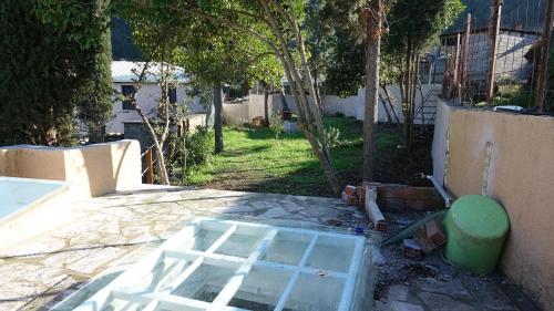 a backyard with a glass window on the ground at The old olive mill house in Aegae