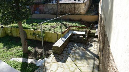 a garden with a bench next to a tree at The old olive mill house in Aegae
