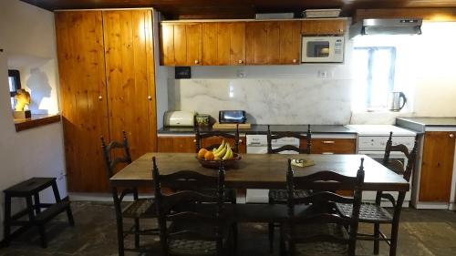 a kitchen with a table with a bowl of fruit on it at The old olive mill house in Aegae