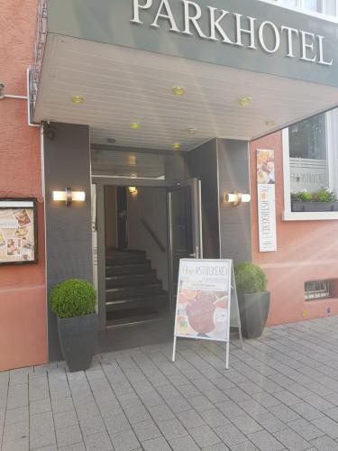 a restaurant with a sign in front of a building at Parkhotel Villingen und Boardingzimmer in Villingen-Schwenningen