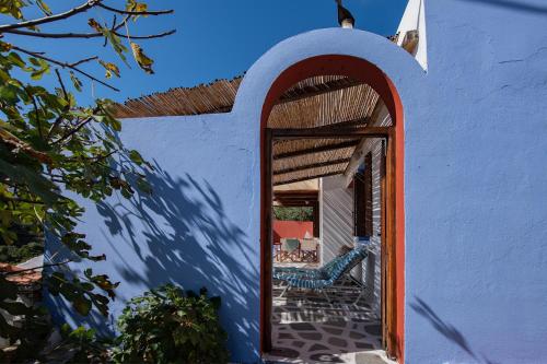 a white building with an archway on a patio at Asteri Apartments in Alonnisos Old Town