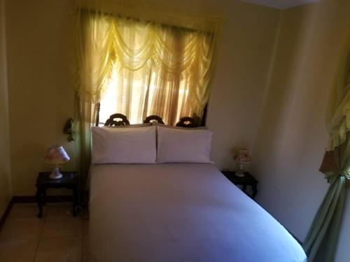 a bedroom with a large white bed with a window at Cliffe Ranch in Mandeville